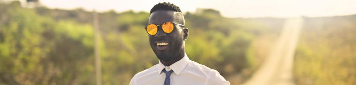 Happy man in formal wear and glasses in countryside