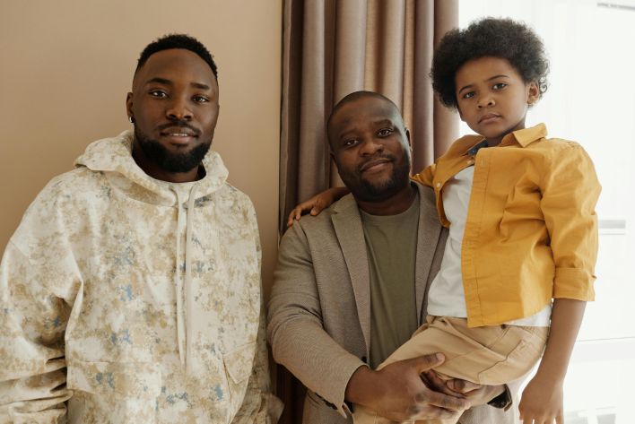 A heartwarming indoor family portrait featuring a father and two sons.