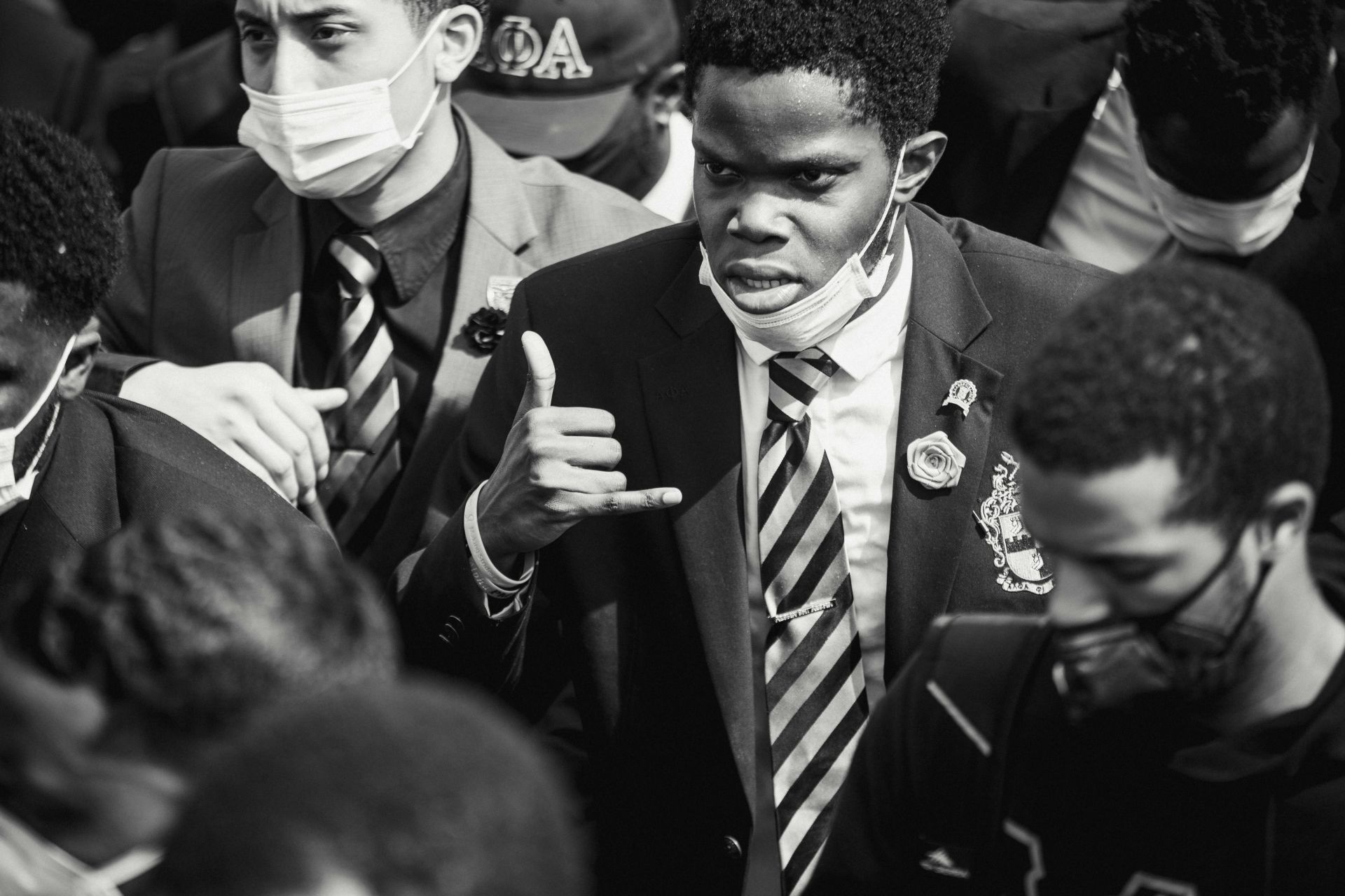 Adults in formal attire and face masks participating in a peaceful protest.